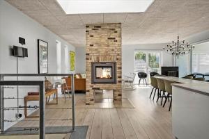 a living room with a fireplace and a dining room at 20503-Samso-Strandkrogen-37 in Sælvig