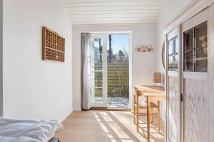 a bedroom with a desk and a table and a door at 20414-Samso-Strandvejen-63 in Ballen