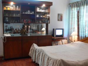 a bedroom with a bed and a bar with a television at Petite Homestays in New Delhi
