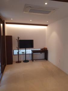 a room with a flat screen tv and a desk at 안동한옥스테이 휴 in Andong