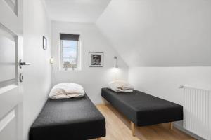 two beds in a room with white walls at 20417-Samso-Ballenvej-26 in Ballen
