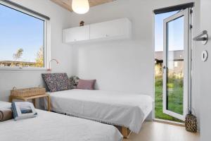 een slaapkamer met twee bedden en een raam bij 20142-Samso-Laerkevej-9-C in Nordby