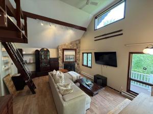 a living room with a couch and a tv at Luxury Mountain Getaway - 6 bed, 3 bath, hot-tub, fire-pit, game-room in Hunter