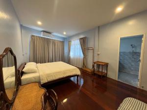 a bedroom with a bed and a window in it at Saen Saran property in Sathani Bang Ramat