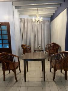 a dining room with a table and chairs and a chandelier at Saen Saran property in Sathani Bang Ramat