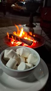 a bowl of marshmallows in front of a fire at Pousada Luar de Penedo in Penedo