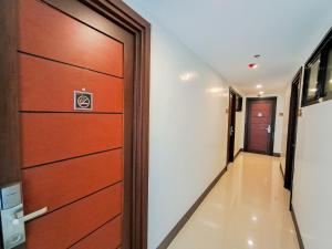 a corridor with a wooden door and a hallway at Top Star Hotel Dipolog in Sampong