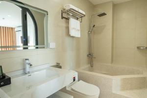 下龙湾Azure Bay Hotel的带水槽、马桶和浴缸的浴室