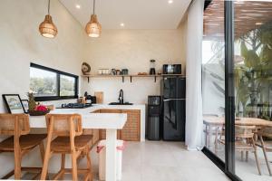 a kitchen with a table and chairs and a refrigerator at Lucky Villa 1 in Uluwatu