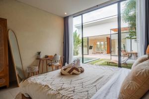 a bedroom with a bed and a large window at Lucky Villa 1 in Uluwatu +46 photos