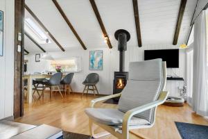 a living room with a chair and a fireplace at 20223-Samso-Rosenvej-8 in Tanderup