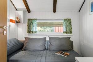 a bed in a small room with a window at 20223-Samso-Rosenvej-8 in Tanderup
