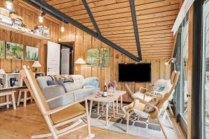 a living room with a couch and chairs and a television at 20114-Samso-Blamejsevej-9 in Nordby