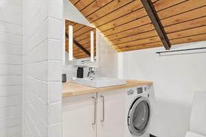 a bathroom with a sink and a washing machine at 20114-Samso-Blamejsevej-9 in Nordby +17 photos