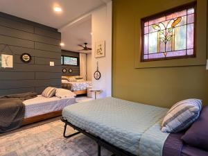a bedroom with two beds and a stained glass window at Gwen's Cottage at Water's Edge in Portersville