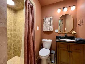 a bathroom with a toilet and a shower and a sink at Gwen's Cottage at Water's Edge in Portersville +21 photos