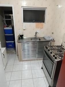 eine Küche mit Spüle und Herd in der Unterkunft Caiçara de frente para mar in Praia Grande