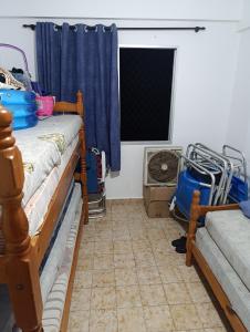 ein Zimmer mit zwei Etagenbetten und einem Fenster in der Unterkunft Caiçara de frente para mar in Praia Grande + 2 Fotos