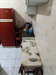 eine kleine Küche mit einem Tisch und einem Tisch sidx sidx in der Unterkunft Caiçara de frente para mar in Praia Grande