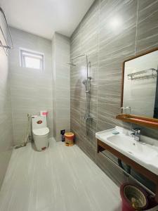 ein Badezimmer mit Toilette, Waschbecken und Spiegel in der Unterkunft Mini Villa in La Gi + 180 Fotos