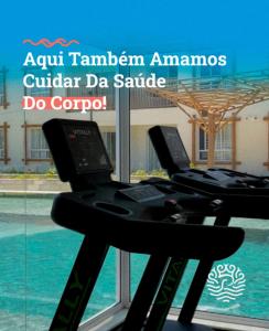 a treadmill desk with two laptops on it in front of a window at Pipa Privilege Ocean in Pipa +2 photos