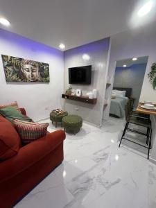 サンファンにあるChic 1BR 10 off jet Ski at Archi Rentalの赤いソファとテレビのあるリビングルーム
