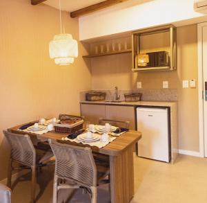 a kitchen with a wooden table with chairs and a counter at Pipa Privilege Ocean in Pipa
