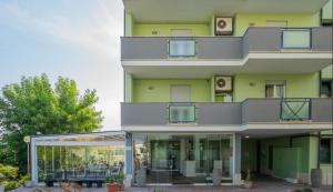 フィウミチーノにあるIsa Residence Fiumicino Airportのバルコニーとパティオ付きの緑豊かな建物