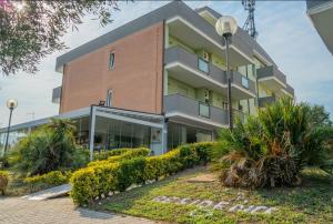 un gran edificio con arbustos delante de él en Isa Residence Fiumicino Airport, en Fiumicino