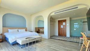 a bedroom with a bed and a table and a door at Auganic Hotel in Wujie +69 photos