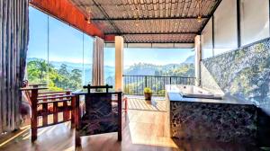 a room with a balcony with a view of the mountains at Rainbow Sky Cottage in Ella
