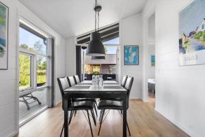 Nordby20150-Samso-Solsortevej-22的配有黑色桌子和椅子的餐厅