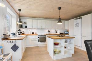 a kitchen with white cabinets and a wooden ceiling at AE285-Aeroskobing-Hanses-Ager-4 in Ærøskøbing