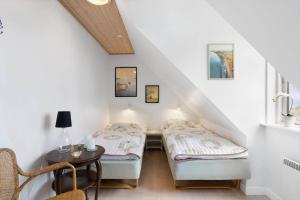 a attic room with two beds and a table at AE285-Aeroskobing-Hanses-Ager-4 in Ærøskøbing