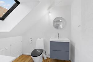 a white bathroom with a sink and a mirror at AE208-Aeroskobing-Brogade-4 in Ærøskøbing +14 photos