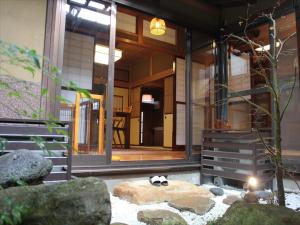 a cat laying on a rock in front of a house at K's Villa Hida-an in Takayama