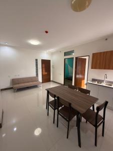 a living room with a wooden table and chairs at Lheaf Residences and Serviced Apartments in Cebu City