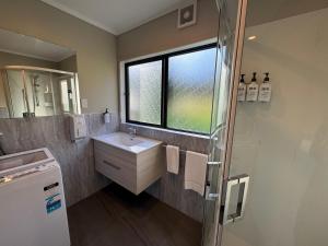 a bathroom with a sink and a shower with a window at Comfort Inn Sunset in Thames +132 photos