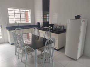a kitchen with a table and chairs and a refrigerator at Excelente casa em Lavras in Lavras