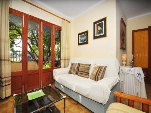 a living room with a white couch and a glass table at Terraced House Alcudia near Beach in Port d'Alcudia