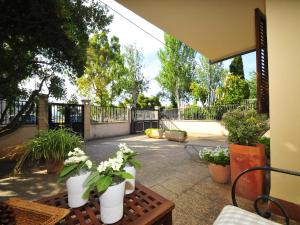 a patio with flowers in white vases on a table at Terraced House Alcudia near Beach in Port d'Alcudia