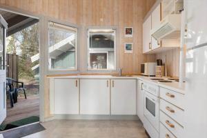 a kitchen with white cabinets and a large window at SB113-Sydals-Oddermosen-11 in Sønderby