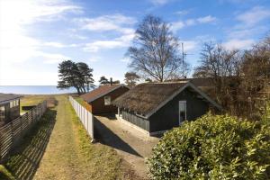 a group of buildings in a field with a fence at SB113-Sydals-Oddermosen-11 in Sønderby