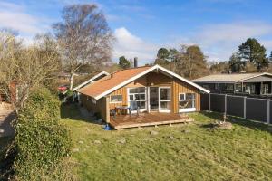 a small house with a deck in a yard at SB113-Sydals-Oddermosen-11 in Sønderby +11 photos