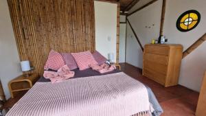 a bedroom with a bed with pink sheets and a dresser at Cabane Limon - Salento in Salento