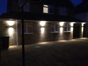 a house with lights on the side of it at night at Alder Lodge in Cambridge