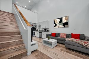 a living room with a couch and a staircase at Chic Modern Loft in Hollywood 1 Bedroom with Balcony & Free Secure Parking in Los Angeles