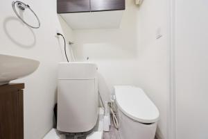a white bathroom with a toilet and a sink at 32 とりっぱーずホテル高田馬場 in Tokyo