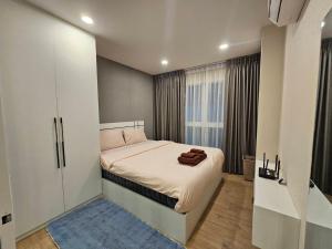 a small bedroom with a bed and a large window at คอนโดอีสวิลบางแสน ห้อง 7 in Ban Hua Khao Sammuk