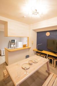 a kitchen and dining room with a wooden table at SN3A 大須徒歩10分 TV,パソコンなど設備充実 木の温もりあるナチュラルな部屋 8人可 10-minute walk to Osu Fully equipped with TV, PC, etc Natural wooden warm rooms Accommodates 8 people in Nagoya